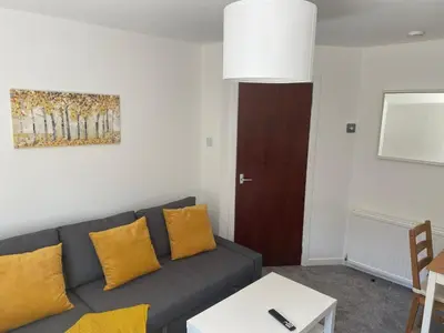 a living room with a gray couch and yellow pillows at Glen Cannich - Top Location, 2BR Accessible apt in Inverkeithing