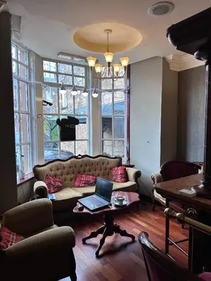 a living room with a couch and a laptop on a table at The Villa Hamilton in Hamilton
