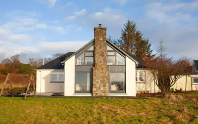 a white house with a brick chimney and windows at 5 Bed Family Home Lochwinnoch in Lochwinnoch