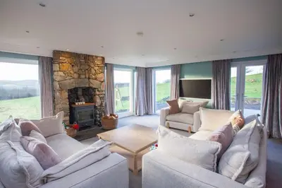 a living room with two couches and a stone fireplace at 5 Bed Family Home Lochwinnoch in Lochwinnoch