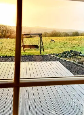a window view of a field with a bench and a horse at 5 Bed Family Home Lochwinnoch in Lochwinnoch