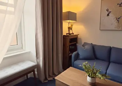 a living room with a blue couch and a window at Peaceful Edinburgh Retreat - Quiet Central 1-Bed in Edinburgh