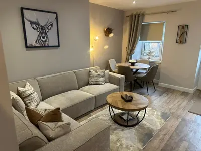 a living room with a couch and a table at BOFA Snug Apartment in Bridge of Allan