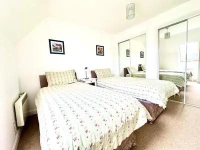 two beds in a room with white walls and windows at Barrmor View in Kilmartin