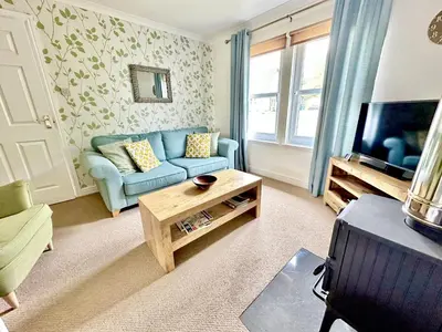 a living room with a blue couch and a tv at Barrmor View in Kilmartin
