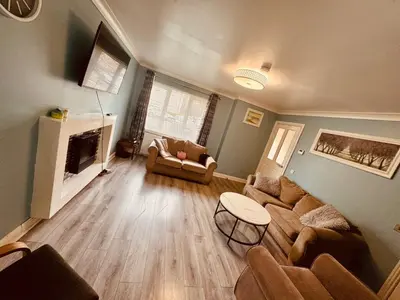 a living room with a couch and a fireplace at Glasgow 3 bed Guest House in Glasgow