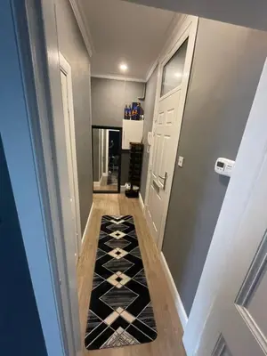 a hallway with a black and white tile floor at Fountain park get away one bedroom in a 2 bedroom apartment in Edinburgh