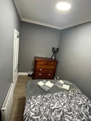 a bedroom with a bed and a dresser at Fountain park get away one bedroom in a 2 bedroom apartment in Edinburgh