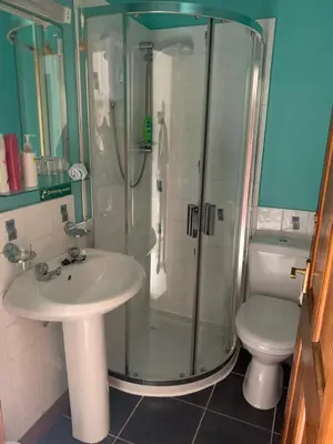 a bathroom with a shower and a sink and a toilet at Whitestone Cottage in Turnberry