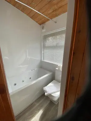 a white bathroom with a tub and a window at Rowardennan Rooms in the lodge Lodge no 2 in Rowardennan