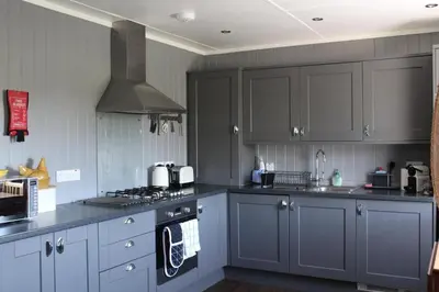 a kitchen with gray cabinets and a stove top oven at Fortingall Cottage - Dalmally in Dalmally
