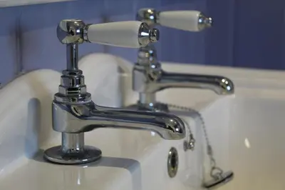 a bathroom sink with two faucets on it at Fortingall Cottage - Dalmally in Dalmally