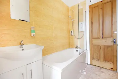 a bathroom with a sink and a tub and a shower at Townhead Apartments Glasgow Airport in Paisley