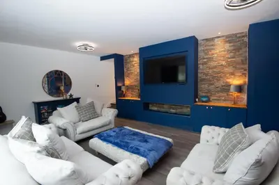 a living room with white furniture and a blue wall at Private Home North of Dunblane in Braco