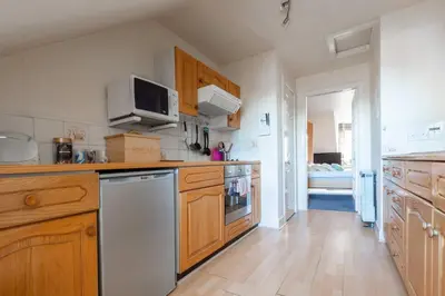 a kitchen with wooden cabinets and a stove top oven at Edinburgh City Retreat - EDINBURGH CITY CENTRE 3 min walk to Edinburgh castle in Edinburgh