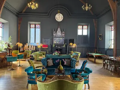 a room with chairs and tables and a clock on the wall at The Old Church Isle of Bute in Port Bannatyne
