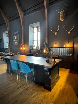 a large table in a room with two blue chairs at The Old Church Isle of Bute in Port Bannatyne