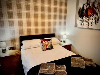 a bedroom with a bed with two books on it at Hide-a-While in Rothesay