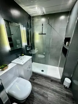 a bathroom with a shower and a toilet and a sink at Hide-a-While in Rothesay