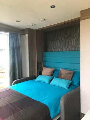 a bed in a room with a blue headboard at Cnocanreoch Farm Glamping in Kilmory