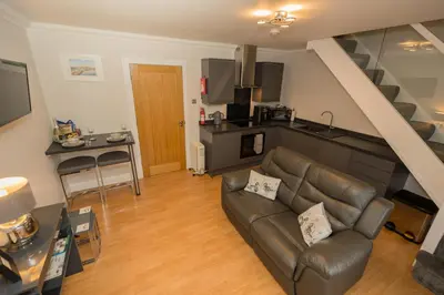 a living room with a couch and a kitchen at Tigh Na Cille Studio in Taynuilt