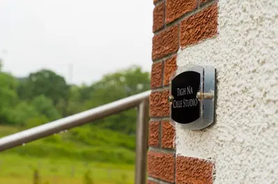 a sign on the side of a brick wall at Tigh Na Cille Studio in Taynuilt