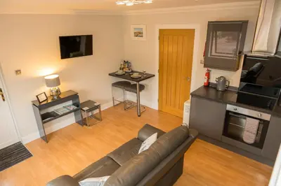 a living room with a couch and a table at Tigh Na Cille Studio in Taynuilt