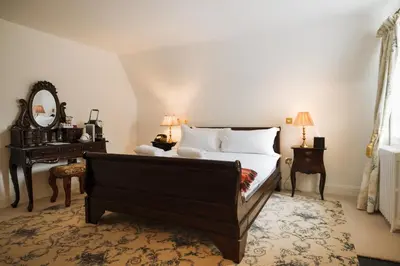 a bedroom with a bed and a table and a mirror at Islay House in Bridgend