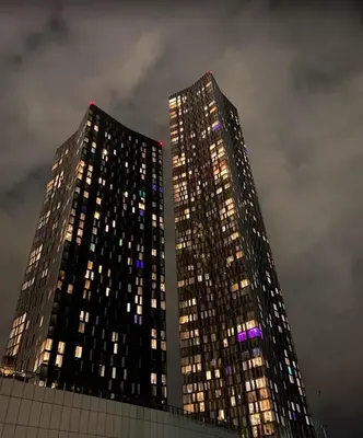two tall buildings at night with lights on them at victoria resedent in Moffat