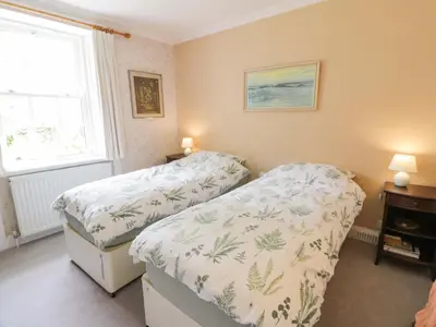 a bedroom with two twin beds and a window at Townhead of Auchenbainzie in Thornhill