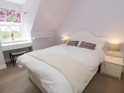a white bedroom with a white bed and a window at Marshill Farm House in Lanark