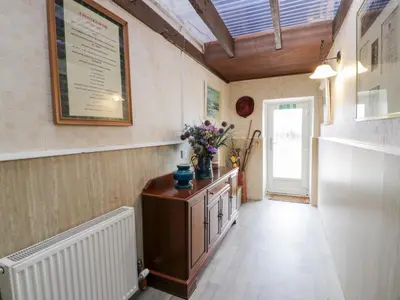 a hallway with a table with flowers on it at Marshill Farm House in Lanark