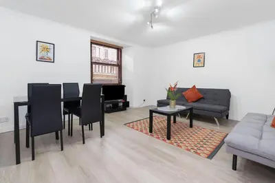 a living room with a table and a couch at Free Parking - Sleeps 6 - Central - New Interior in Greenock