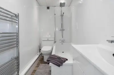 a white bathroom with a toilet and a bath tub at Free Parking - Sleeps 6 - Central - New Interior in Greenock