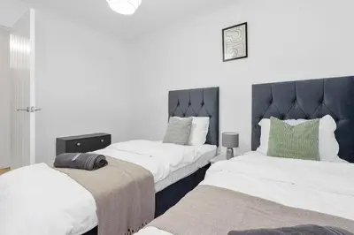 two beds in a room with white walls at Free Parking - Sleeps 6 - Central - New Interior in Greenock