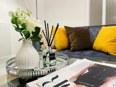 a coffee table with a vase of flowers and a magazine at Lovely 1-bedroom Apt in Glasgow City near Subway in Glasgow