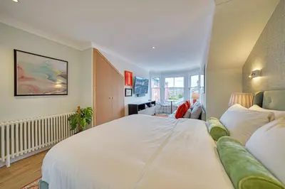 a bedroom with a large white bed in a room at City Oasis Craigpark Residence in Glasgow