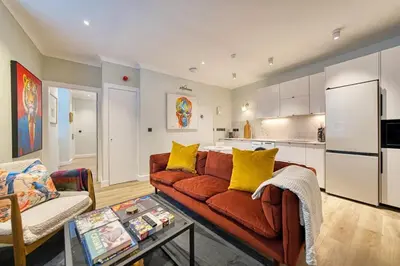 a living room with a couch and a kitchen at City Oasis Craigpark Residence in Glasgow