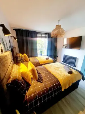 a bedroom with two beds with yellow sheets at Modern Apartment - FREE parking in Glasgow