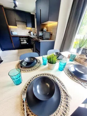 a table with black plates and utensils on it at Modern Apartment - FREE parking in Glasgow