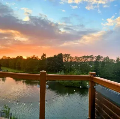 a view of a pond with a wooden fence at Lakeside Lodge - Lakeside Lodge Retreat - Golf & Spa, Gleneagles in Dunning