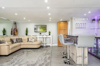 a living room with a couch and a bar at 2 Bedroom Garden Flat in Bearsden