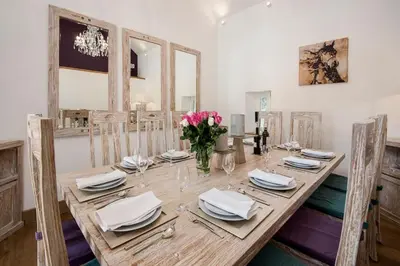 a wooden table with plates and napkins and flowers on it at Arrochar House in Tarbet