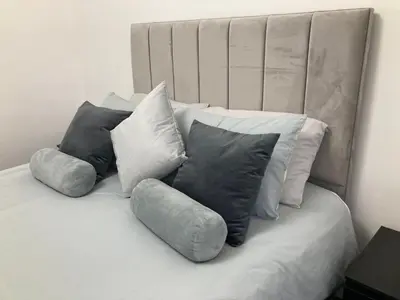 a pile of pillows sitting on top of a bed at Modern and stylish 3 bedroom 2 bathroom west end house with Free WiFi and parking in Scotstoun West Station
