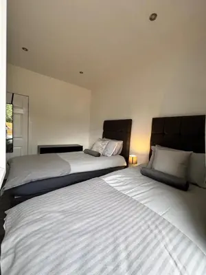 two beds sitting next to each other in a bedroom at Modern and stylish 3 bedroom 2 bathroom west end house with Free WiFi and parking in Scotstoun West Station