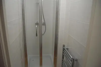 a shower with a glass door in a bathroom at Grassmarket-Old Town Apartment in Edinburgh