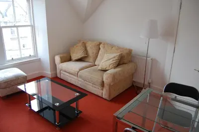 a living room with a couch and a glass table at Grassmarket-Old Town Apartment in Edinburgh