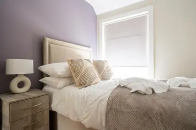 a bedroom with a bed with a mirror and a window at Pinkerton House in Dunfermline