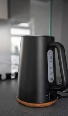 a black coffee mug sitting on top of a counter at Torbrex House in Cumbernauld
