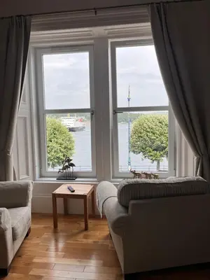 a living room with a couch and two windows at Harbour View in Rothesay